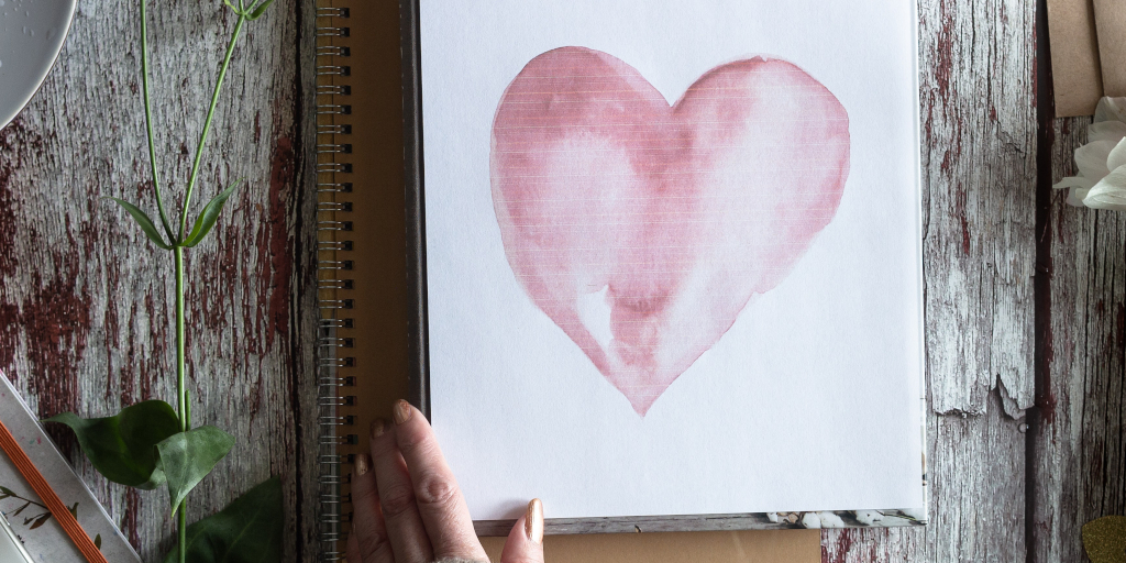 Comedic Timing. Photo by Visual Stories || Micheile on Unsplash. Shows Valentines Card of big pink heart.