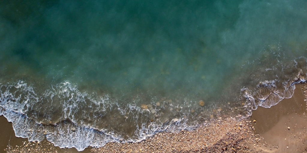 Platja Del Torn_Photo by Jordi Martorell on Unsplash. Shows waves breaking on a shore.